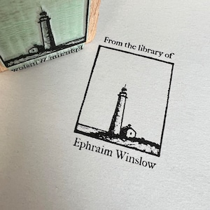 May include: Black and white illustration of a lighthouse with a small building next to it. The text "From the library of Ephraim Winslow" is printed below the image.