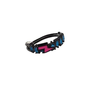 May include: A black ring with a pink lightning bolt design and blue enamel accents.