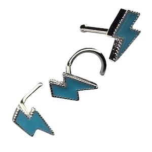 May include: Three silver nose rings with a blue lightning bolt design. The rings are made of surgical steel and are available in a variety of sizes.