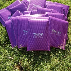May include: A stack of purple padded envelopes with the text "You've Got Nails" printed on them.