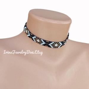 May include: A black beaded choker necklace with a geometric pattern in white, gold, and turquoise. The necklace is displayed on a mannequin. The text "IrinaJewelryBox.Etsy" is visible.