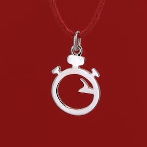 Può includere: Un ciondolo a forma di cronometro argentato su una collana con cordoncino rosso. Il cronometro è un design semplice con un cerchio e una lancetta all'interno.