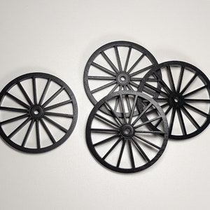 May include: Four black wooden wagon wheels with spokes, arranged in a semi-circle on a white surface.