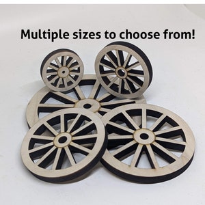 May include: Multiple sizes of wooden wagon wheels with a dark brown stain. The wheels have a classic design with spokes radiating from the center.