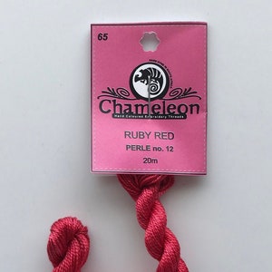 May include: A spool of ruby red embroidery thread, labeled "Chameleon Hand Coloured Embroidery Threads" and "Ruby Red Perle no. 12 20m".