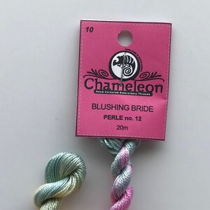 May include: A skein of Chameleon Blushing Bride embroidery thread in a gradient of pink, yellow, and green. The thread is hand-dyed in South Africa and is made of perle cotton size 12. The skein is 20 meters long.
