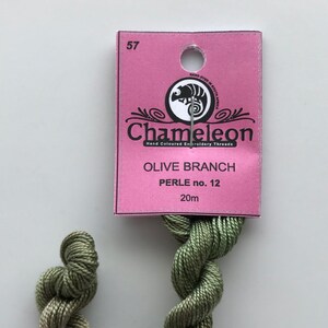 May include: A skein of olive green embroidery floss, labeled "Chameleon Hand Coloured Embroidery Threads Olive Branch Perle no. 12 20m".