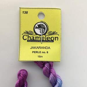 May include: A skein of purple and blue ombre embroidery floss, labeled "Chameleon Jakaranda Perle no. 8 16m".