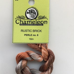May include: A skein of Chameleon Rustic Brick embroidery floss in perle no. 8, hand dyed in South Africa. The floss is a blend of brown, orange, and grey colours. The skein is 16 metres long.