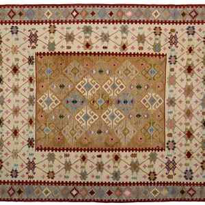 May include: A rectangular area rug featuring a central golden-brown field with white, blue, and brown geometric diamond motifs. The surrounding cream-colored border displays a lattice pattern with small pink, blue, and brown accents.