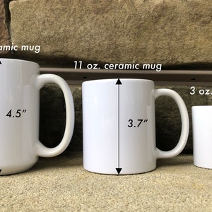 May include: Three white ceramic mugs of different sizes. The largest mug is 15 ounces and measures 4.5 inches tall. The middle mug is 11 ounces and measures 3.7 inches tall. The smallest mug is 3 ounces and measures 2.6 inches tall.
