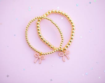 Bedelarmband met kralen - Roze strikbedel (kies kraalgrootte) - Gouden stand