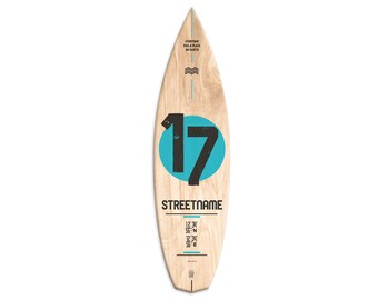 May include: A wooden surfboard with a blue circle and the number 17 in black. The text "STREETNAME" is printed below the circle. The text "EVERYONE HAS A PLACE ON EARTH" is printed at the top of the surfboard. Coordinates are printed below the text "STREETNAME".