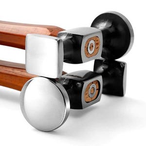 Puede incluir: Tres martillos de metal con mangos de madera. Los martillos tienen cabezas de diferentes formas, incluyendo una cabeza cuadrada, redonda y rectangular. Los martillos están apilados uno encima del otro.
