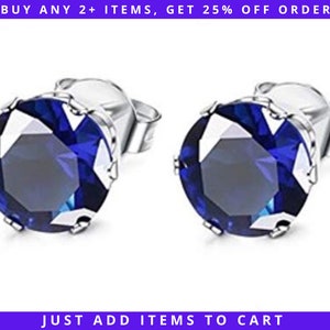 May include: A pair of silver stud earrings with a round, dark blue gemstone in the center. The earrings have a simple, classic design.