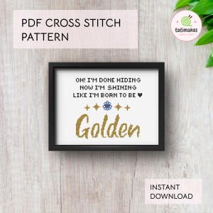 Puede incluir: Un patrón de punto de cruz enmarcado con las palabras "OH! I'M DONE HIDING NOW I'M SHINING LIKE I'M BORN TO BE" encima de la palabra "Golden". El texto está en un estilo de punto de cruz, con un marco negro. Las palabras "PDF CROSS STITCH PATTERN" están en la parte superior.
