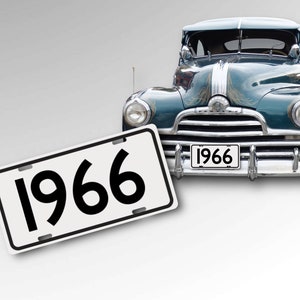 May include: A teal blue vintage car with chrome accents and a white license plate that reads "1966".