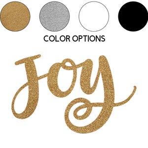 May include: Gold glitter "Joy" lettering on a white background. The word "Joy" is written in a cursive script font.