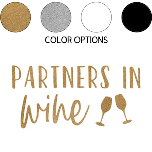 May include: Gold glitter vinyl decal with the text "Partners in wine" and two wine glasses clinking.  The decal is available in gold, silver, white, or black.