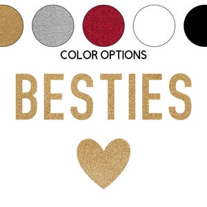 May include: Gold glitter lettering spelling "BESTIES" with a gold glitter heart below.  Five color options are shown above the text: gold, silver, red, white, and black.