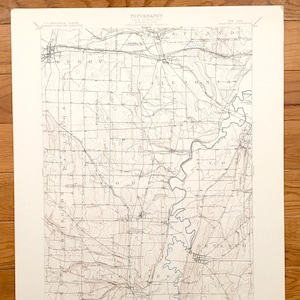 May include: A vintage topographic map of the Caledon, New York area. The map shows the topography of the area with contour lines and labels for towns, rivers, and other features. The map is printed on cream-coloured paper and has a title at the top that reads "TOPOGRAPHY".