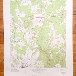 Op de afbeelding: Een vintage topografische kaart van het gebied van Manassas, Virginia. De kaart toont wegen, rivieren en hoogtelijnen. De kaart is gedrukt op papier en heeft een groen-bruin kleurenschema.