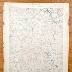 May include: A vintage topographic map of Kentucky, West Virginia, and Ohio. The map shows rivers, roads, and other geographical features. The map is printed on paper and has a light brown colour.