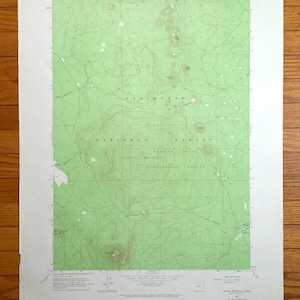 May include: A vintage topographic map of the Mount Hood National Forest in Oregon. The map shows the location of trails, roads, and other features. The map is printed on a green background with brown lines and text.