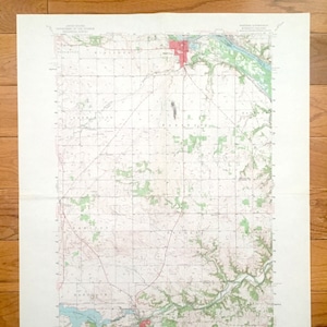 Peut inclure: Une carte topographique vintage des États-Unis, montrant la zone autour de la ville d'Eureka, Kansas. La carte est imprimée en noir et blanc, avec des lignes rouges indiquant les routes et des zones vertes indiquant les forêts. La carte est datée de 1953.