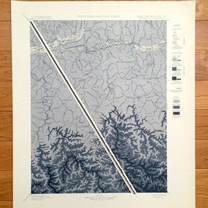 Könnte beinhalten: Eine Vintage-Karte von West Virginia, gedruckt auf cremefarbenem Papier. Die Karte ist in Abschnitte unterteilt, mit einer schwarzen Linie, die diagonal durch die Mitte verläuft. Die Karte zeigt die Topographie des Gebiets, mit Bergen und Flüssen, die in Blautönen dargestellt sind.