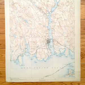 May include: A vintage map of Connecticut, showing the New London area. The map is printed on cream-colored paper and features brown contour lines, blue water features, and black text labels. The map includes the towns of Montville, Waterford, and New London.