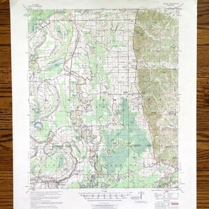 Könnte beinhalten: Eine detaillierte, alte topografische Karte des Mississippi-Gebiets mit Höhenlinien, Wasserläufen und Ortsnamen. Die Karte ist auf gealtertem Papier gedruckt und weist grüne, braune und blaue Farbtöne auf. Text kennzeichnet Herkunft und Maßstab der Karte.