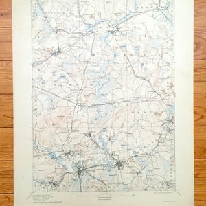 May include: A vintage map of the area around Sherborn, Massachusetts, with a detailed depiction of roads, rivers, and lakes. The map is printed on cream-colored paper and includes the text "SARGENT MUSEUM MASSACHUSETTS  TRADITIONS HOUSE"