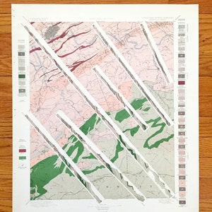 Könnte beinhalten: Eine alte geologische Karte der Appalachen, mit einer weißen Überlagerung von diagonalen Linien, die ein geometrisches Muster erzeugen. Die Karte zeigt verschiedene geologische Formationen und Merkmale, darunter Flüsse, Berge und Täler. Die Karte trägt den Titel "Tennessee, North Carolina, Südost-Blatt".