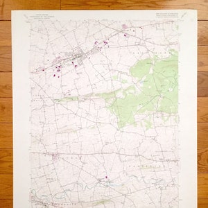 Op de afbeelding: Een vintage topografische kaart van New Holland, Pennsylvania, met wegen, rivieren en hoogtelijnen. De kaart is gedrukt op wit papier met zwarte lijnen en tekst. De kaart heeft de titel "New Holland Quadrangle" en bevat een schaalbalk en een legenda.