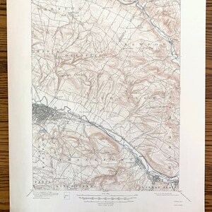 May include: A vintage topographic map of the Utica, New York area. The map shows the terrain with contour lines and includes the names of towns and rivers. The map is printed on paper and has a scale bar and a legend.