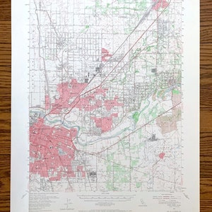 May include: A vintage map of Sacramento, California, showing the city's streets, roads, and waterways. The map is printed in black and white with red and green highlights. The map is titled "Sacramento, California" and includes the text "Fair Oaks Quadrangle".
