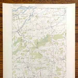 May include: A vintage topographic map of the St. Regis Indian Reservation in New York State. The map shows the reservation's boundaries, rivers, roads, and other features. The map is printed in black and white with green accents.