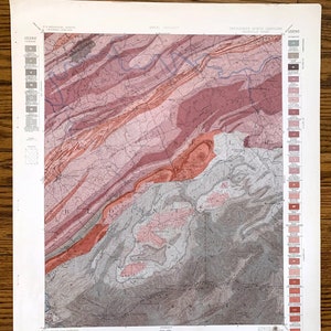 Könnte beinhalten: Eine Vintage-geologische Karte von Tennessee und North Carolina, die die Geologie der Region detailliert darstellt. Die Karte verwendet verschiedene Farben, darunter Rot-, Rosa- und Grautöne, um verschiedene Gesteinsformationen und geologische Merkmale darzustellen. Die Karte enthält eine Legende.