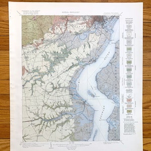 May include: A vintage map of the Delaware Bay area, showing the geological formations and features of the region. The map is titled "Areal Geology" and includes a legend with different colored symbols representing various geological formations. The map is printed on a cream-colored paper and has a faded appearance.