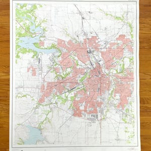 May include: A vintage map of Fort Worth and its surrounding area, showing detailed topographical features. The map uses red, green, and blue to highlight roads, water bodies, and urban zones against a white backdrop. The title "Fort Worth and Vicinity" is printed at the top.