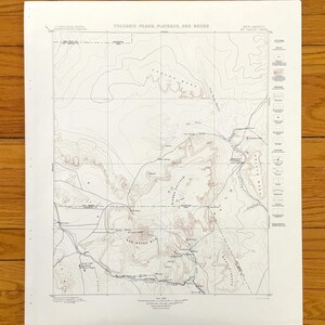Könnte beinhalten: Eine Vintage-topografische Karte von Vulkangipfeln, Plateaus und Hälsen in New Mexico. Die Karte ist auf weißem Papier gedruckt und zeigt Höhenlinien, Straßen und andere Merkmale. Der Titel "Volcanic Peaks, Plateaus, and Necks" ist oben auf der Karte gedruckt, zusammen mit dem Text "New Mexico, Mt. Taylor Sheet".
