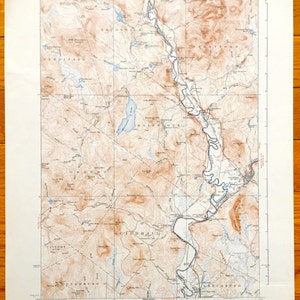 May include: A vintage topographic map of the Bald Mountain area in Maine, USA. The map shows the location of rivers, lakes, mountains, and roads. The map is printed in black and white with brown and blue accents. The map is titled "Bald Mountain, NH" and is dated 1951.