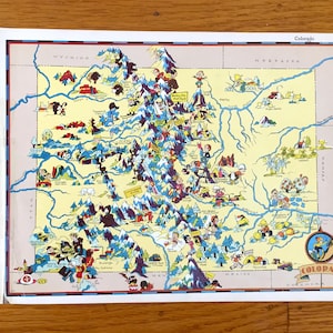 Puede incluir: Un mapa ilustrado vintage de Colorado con personajes de dibujos animados que representan diversas actividades y puntos de referencia. El mapa está sobre un fondo blanco con un borde azul y la palabra "Colorado" en una pancarta roja en la parte inferior.