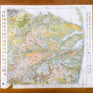 May include: A vintage geological map of the New Jersey coastal area, featuring a detailed color-coded key and various geological formations.