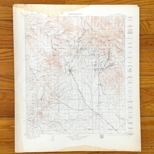 Puede incluir: Un mapa topográfico antiguo con la palabra "TOPOGRAPHY" en la parte superior. El mapa presenta líneas de contorno detalladas, nombres de lugares y una leyenda. El papel ha envejecido, mostrando una ligera decoloración en los bordes.