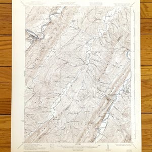 Puede incluir: Un mapa topográfico antiguo con detalles geográficos, incluyendo ríos, montañas y carreteras. El mapa está impreso en papel envejecido con una paleta de colores sepia. El mapa representa el río Potomac y sus alrededores.