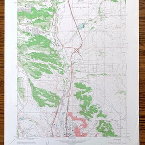 Puede incluir: Un mapa topográfico vintage del área de Rock Springs, Wyoming. El mapa muestra carreteras, ríos y cambios de elevación. El mapa está impreso en papel y tiene un borde marrón.