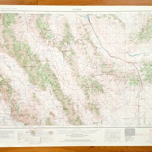 Puede incluir: Un mapa topográfico vintage del área de Dubois, Wyoming. El mapa muestra la ubicación de montañas, ríos y otras características geográficas. El mapa está impreso en un fondo blanco con líneas negras y texto. El mapa está titulado "DUBOIS" y tiene una escala de 1:250.000.