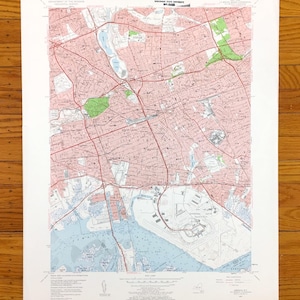 May include: A vintage map of the Boston, Massachusetts area, showing streets, roads, and waterways. The map is printed in black and red ink on a white background. The map is titled "Boston, Massachusetts" and includes the text "C.J.ORAT - DEPT. - INT. - MAP LIBRARY - WORCESTER STATE UNIVERSITY - 841-843".